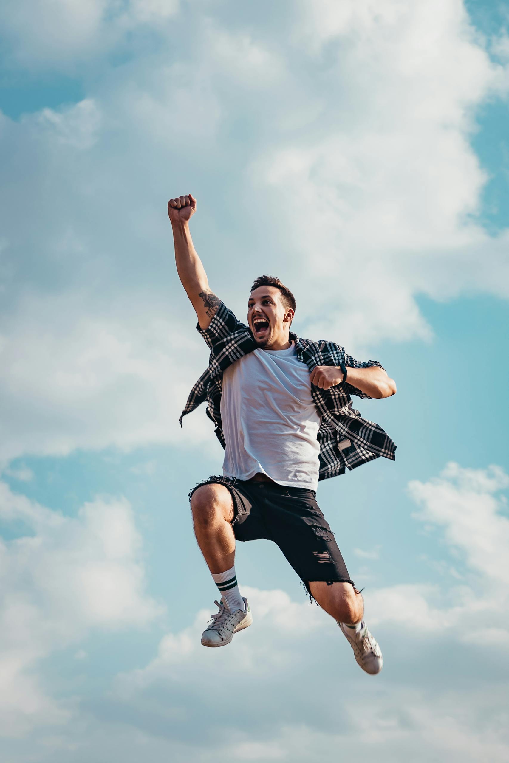 Melbourne Hypnosis Quit Smoking Program | Quit Fast, Naturally, and Permanently (2025 Guide) 1 A joyful young man jumps midair with clouds and blue sky in the background, exuding energy and freedom.