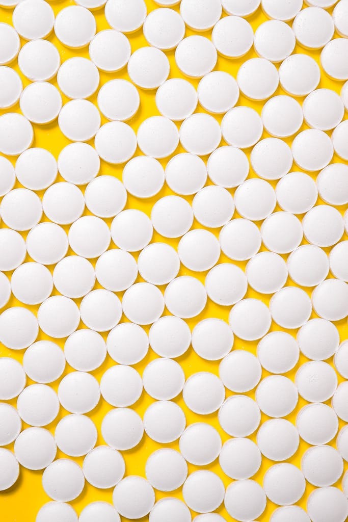 White round pills on a vibrant yellow background showcasing a pharmaceutical theme.
