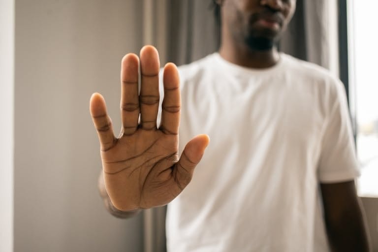 Man raising hand to decline cigarette - social smoker health risks Melbourne hypnotherapy