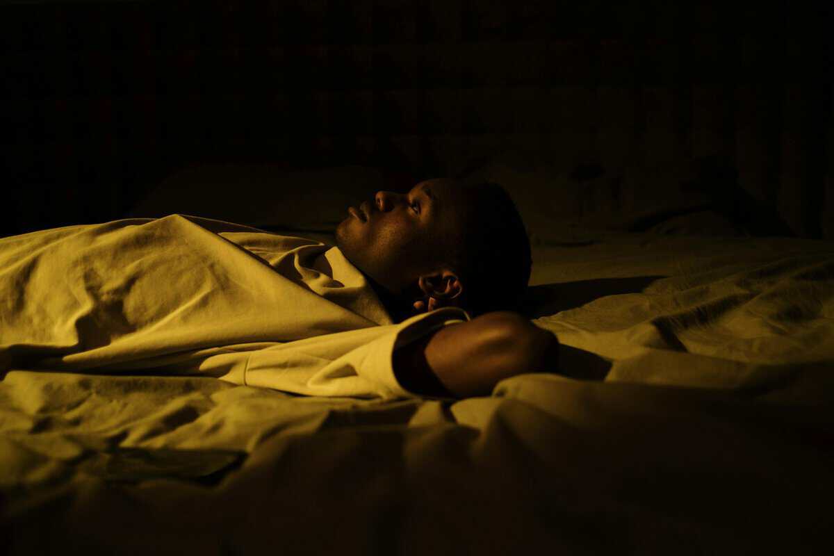 Person lying awake staring at ceiling at night - smoking and insomnia connection Melbourne hypnotherapy
