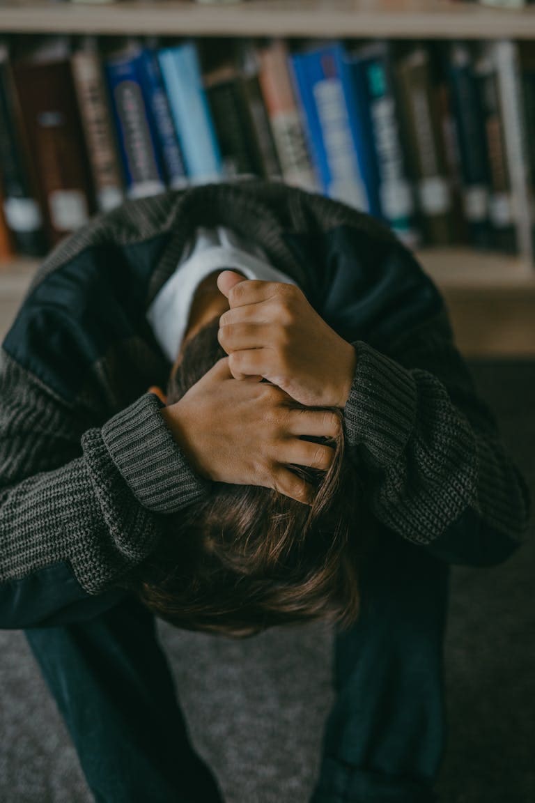 Person sitting with head in hands frustrated after relapsing after quitting smoking Melbourne hypnotherapy