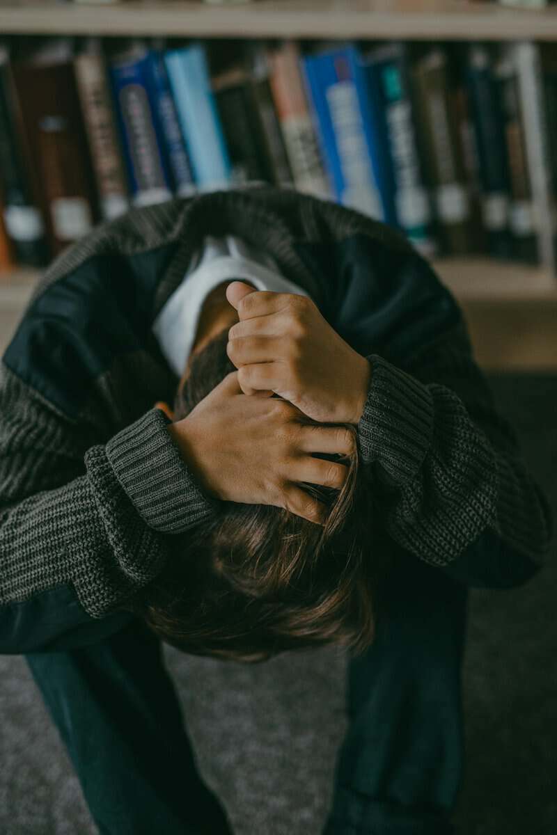Person sitting with head in hands frustrated after relapsing after quitting smoking Melbourne hypnotherapy