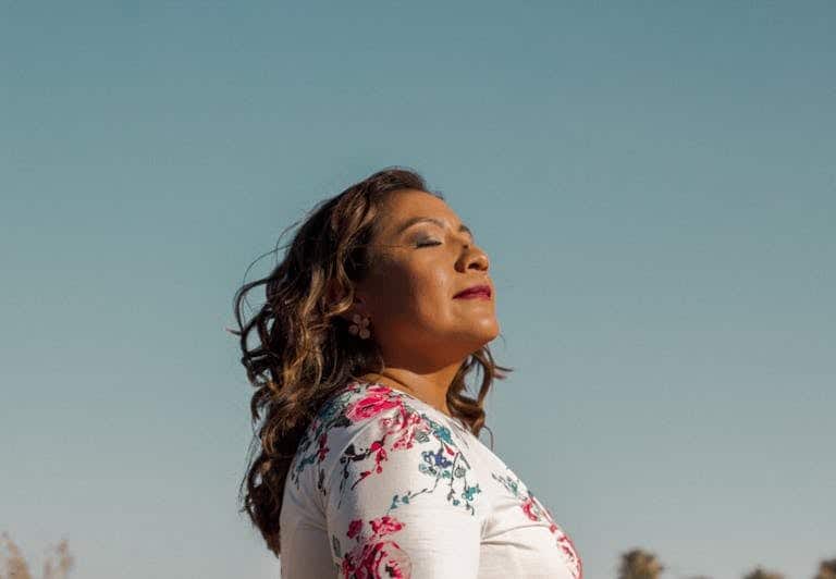 Person breathing deeply and smiling outdoors after quitting smoking without withdrawal Melbourne hypnotherapy