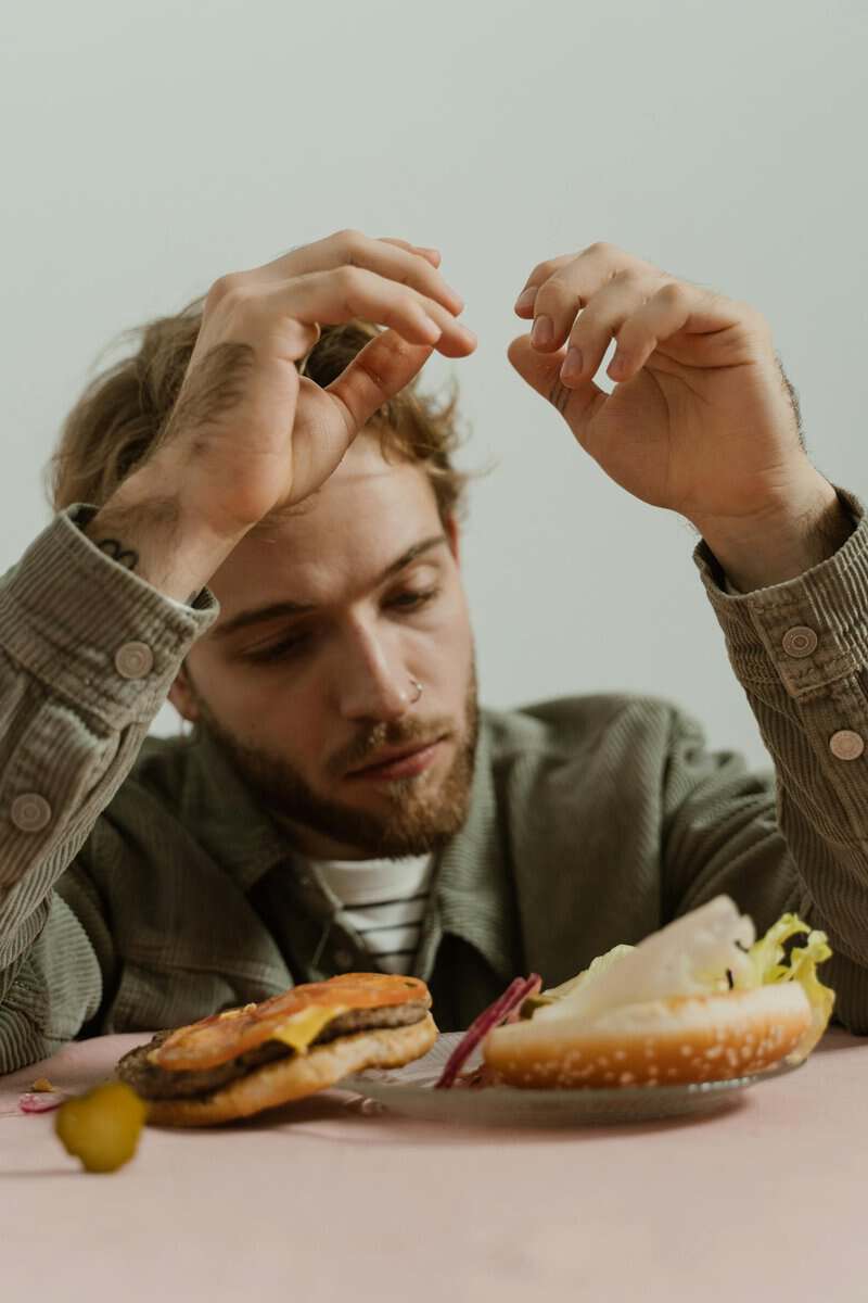 Person looking frustrated with diet food representing why hypnotherapy for weight loss targets the subconscious mind
