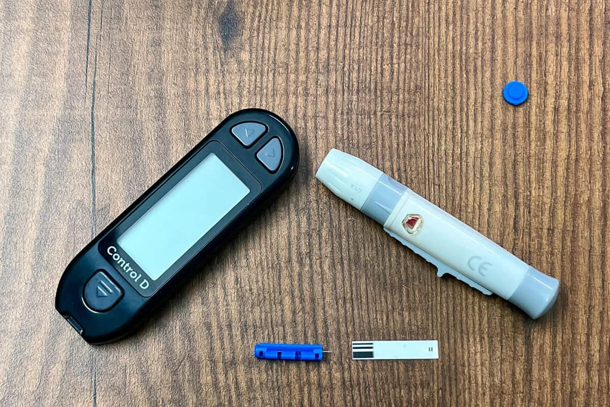 Cigarette and blood glucose monitor side by side showing the link between smoking and diabetes in Australia